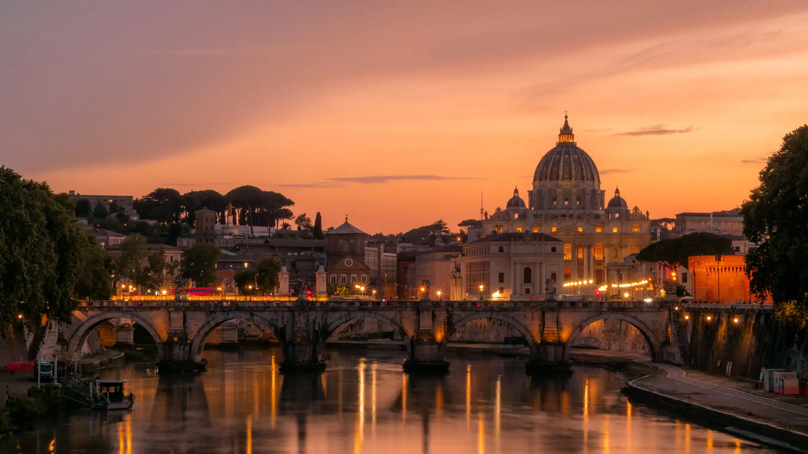 Petersdom-Kuppel im Abendlicht über dem Tiber